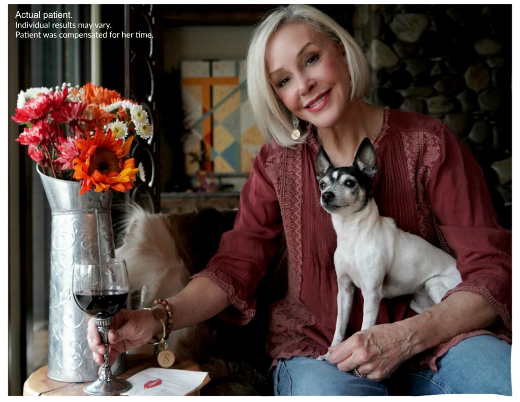 Sheree Frede of the SheSHeShow having a glass of red wine holding her dog Miss Pippa