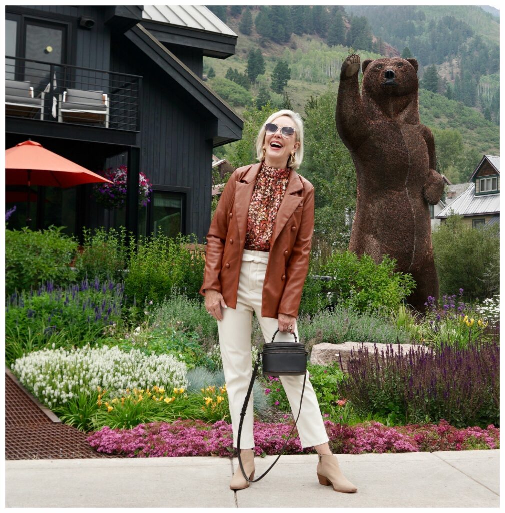 Sheree Frede wearing faux leather off white pants and rust colored faux leather jacket