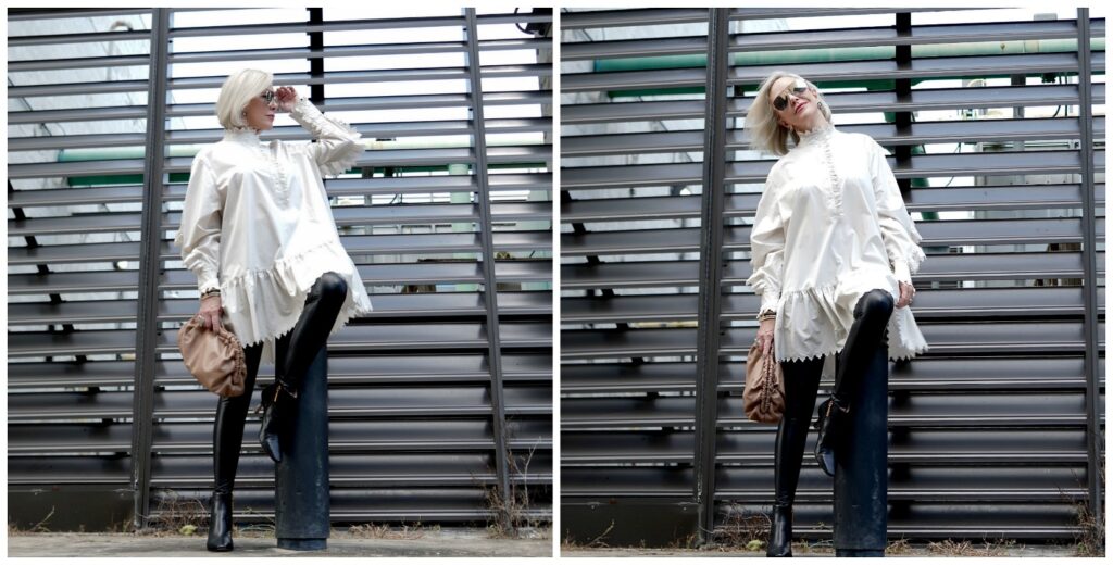 Sheree Frede of the SheShe Show posing in front of grid wearing a white balloon tunic over faux leather leggings