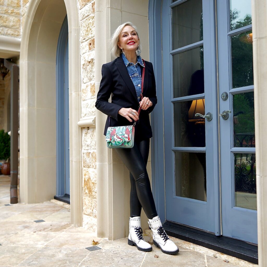 Sheree Frede of the SheShe Show standing against a wall wearing all black with white and black combat boots