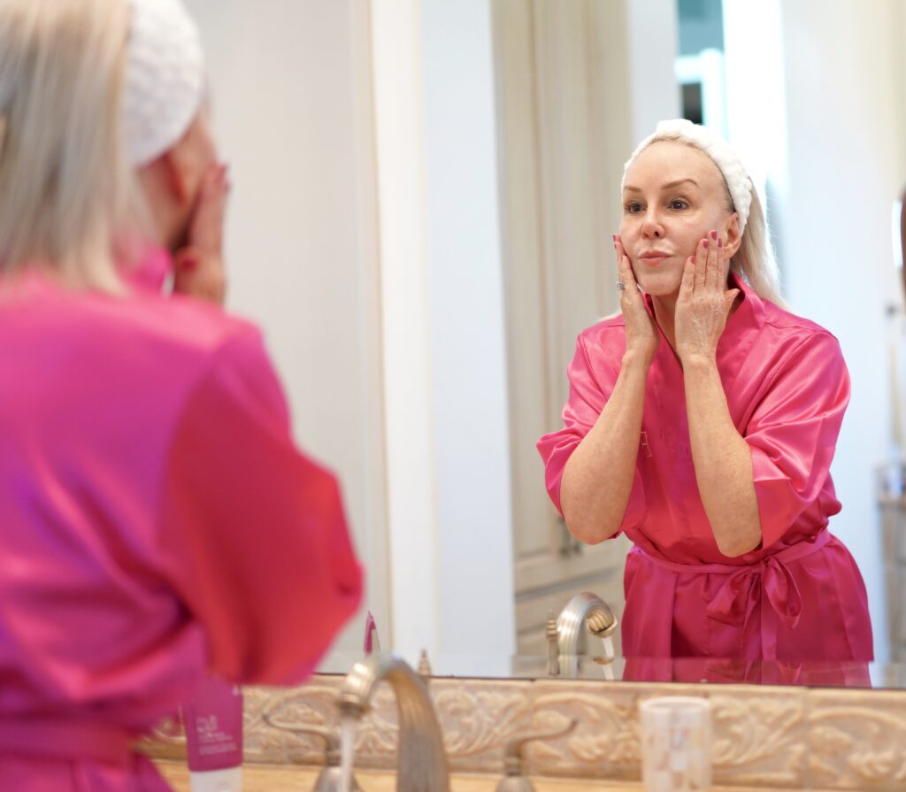 Sheree frede in pink robe applying face cream