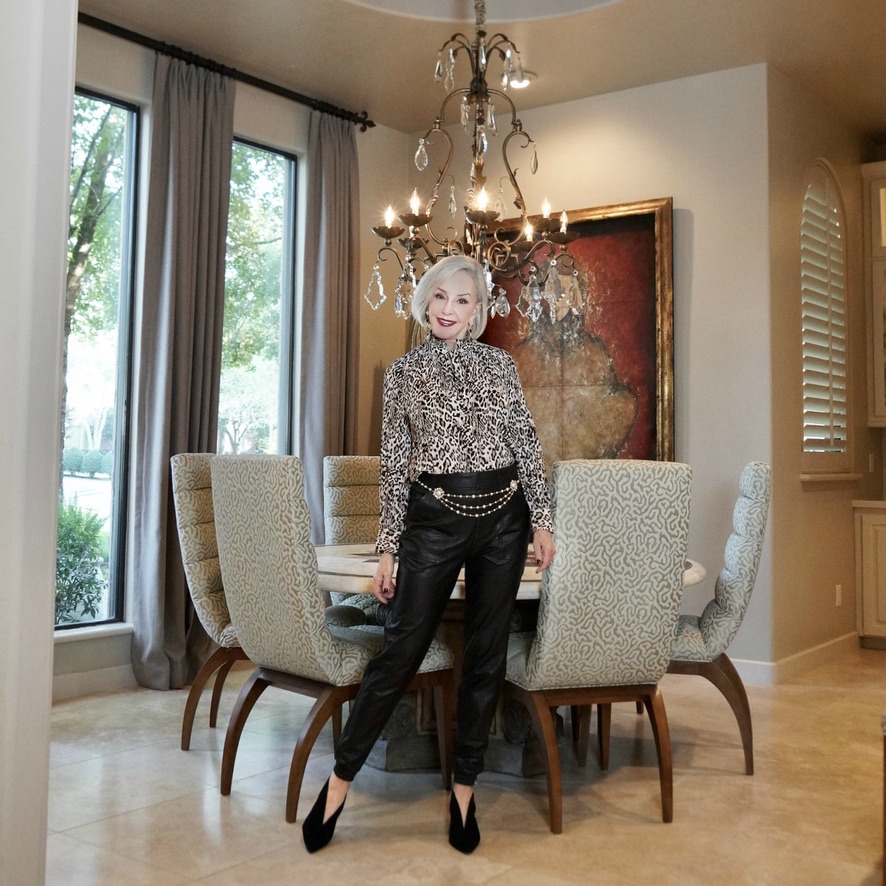 sheree frede of sheshe show in dining room wearing leather joggers and leopard blouse