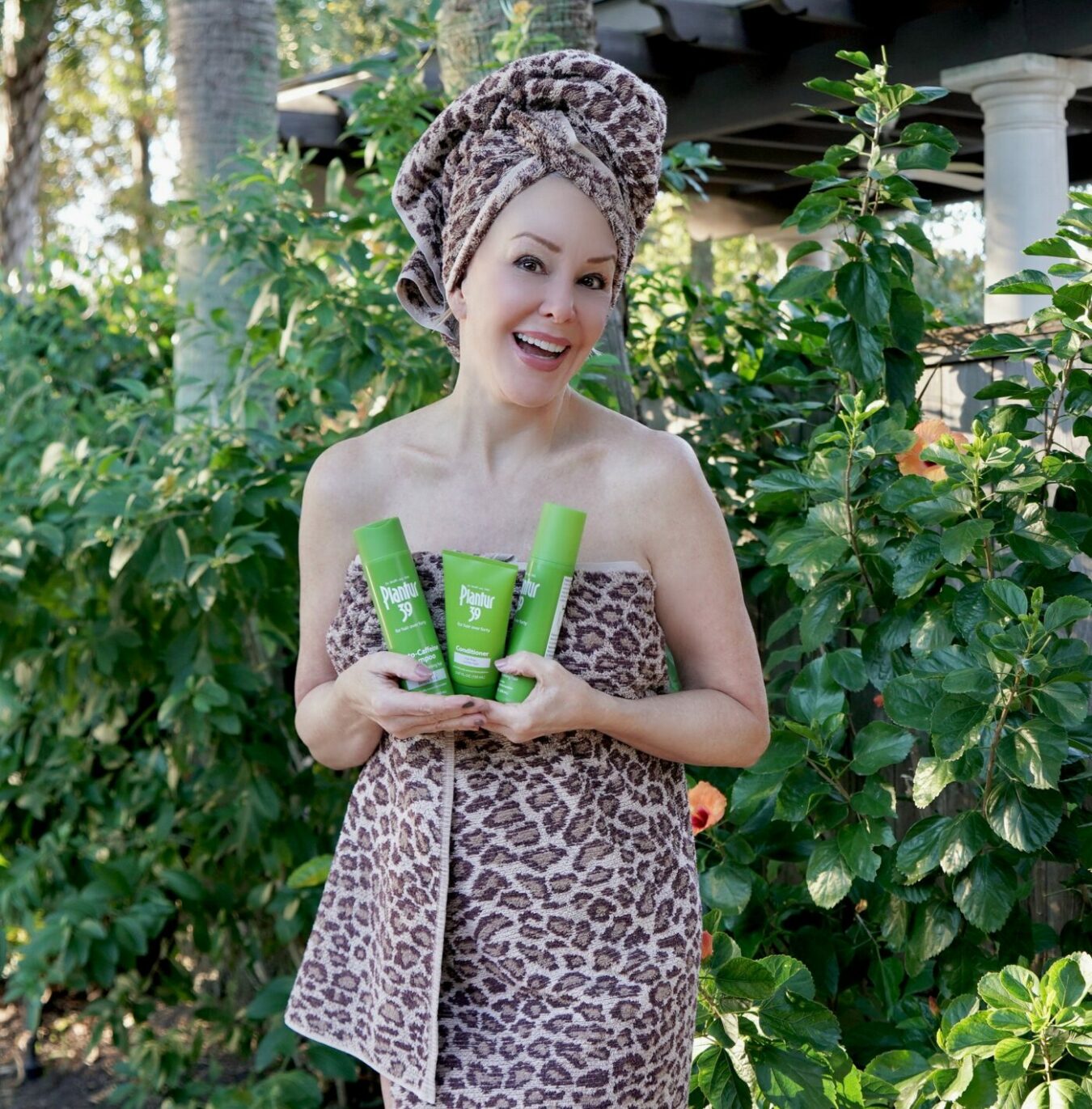 Sheree Frede of the SheShe Show wearing a leopard print towel holding Plantur 39 products