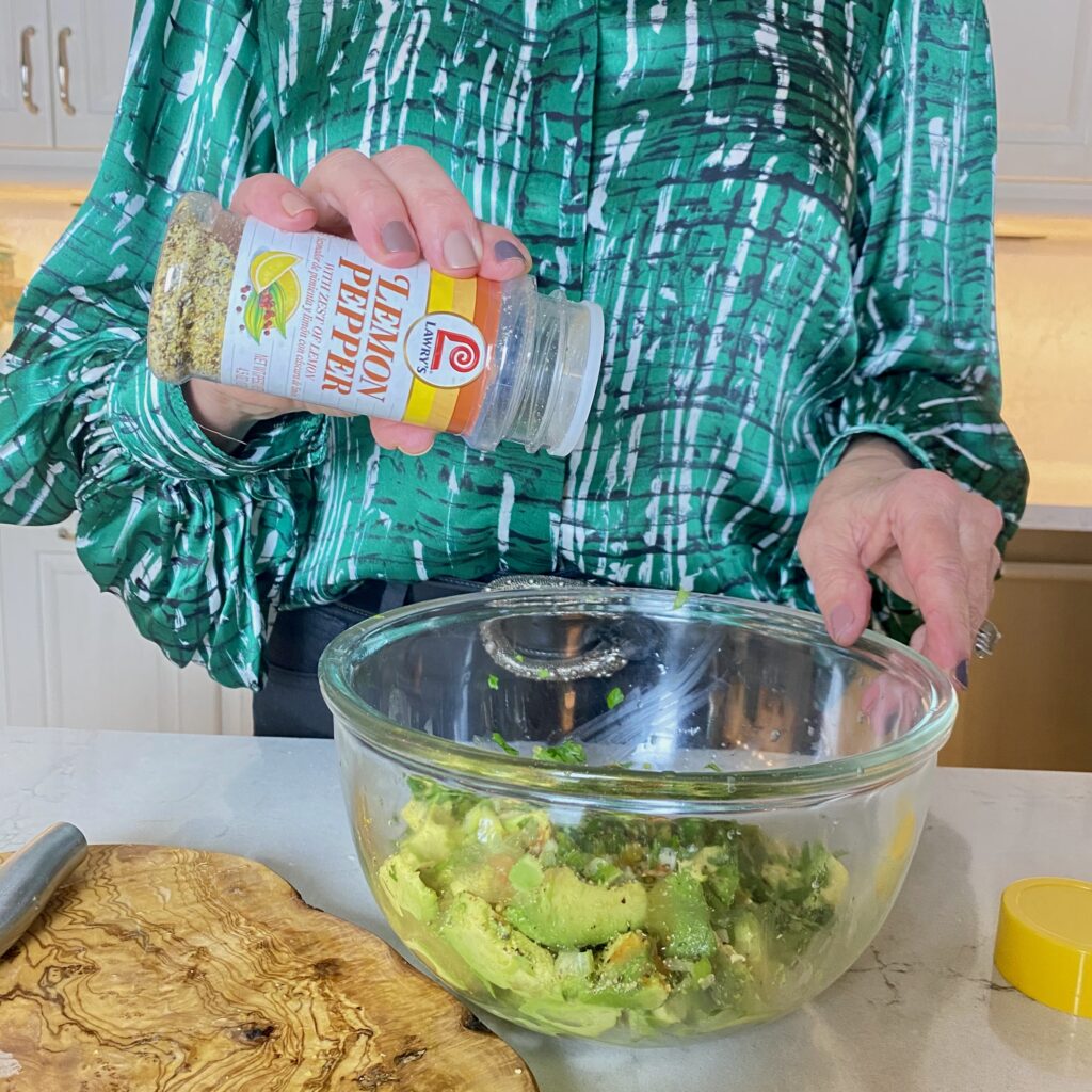 Sheree Frede of the SheShe Show in the kitchen making guacamole wearing a green print shirt