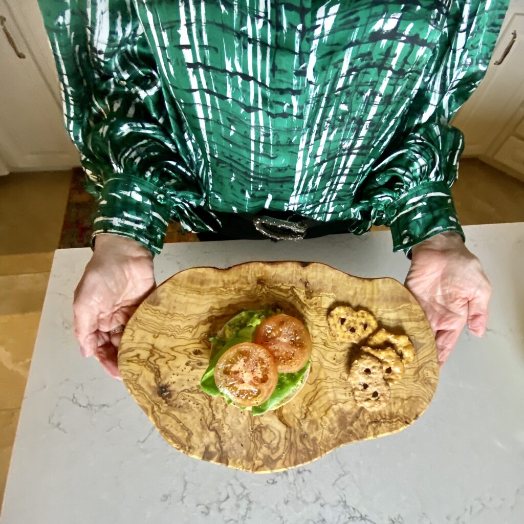 Sheree Frede of the SheShe Show in the kitchen making guacamole wearing a green print shirt