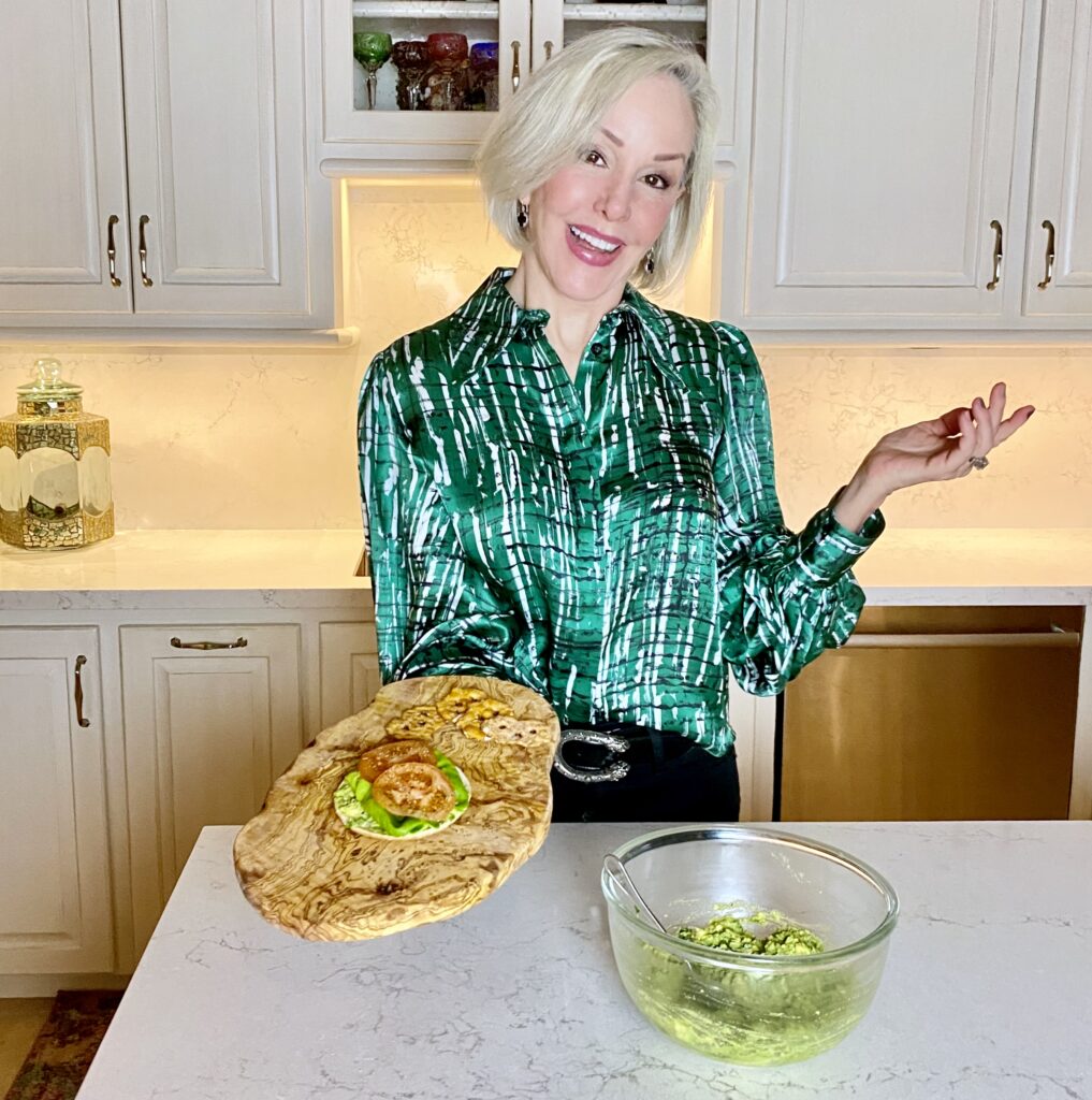 Sheree Frede of the SheShe Show in the kitchen making guacamole wearing a green print shirt