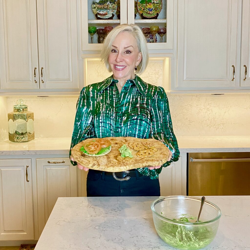 Sheree Frede of the SheShe Show in the kitchen making guacamole wearing a green print shirt