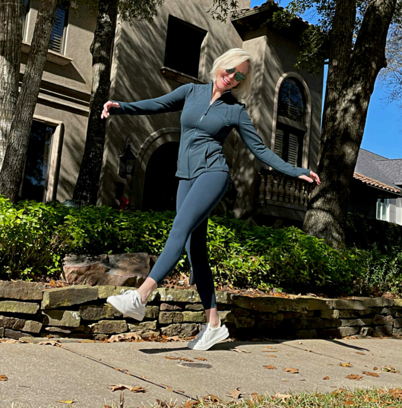 Sheree Frede of the SheShe Show wearing a dark teal lululemon leggins and zip front jacket with sneakers