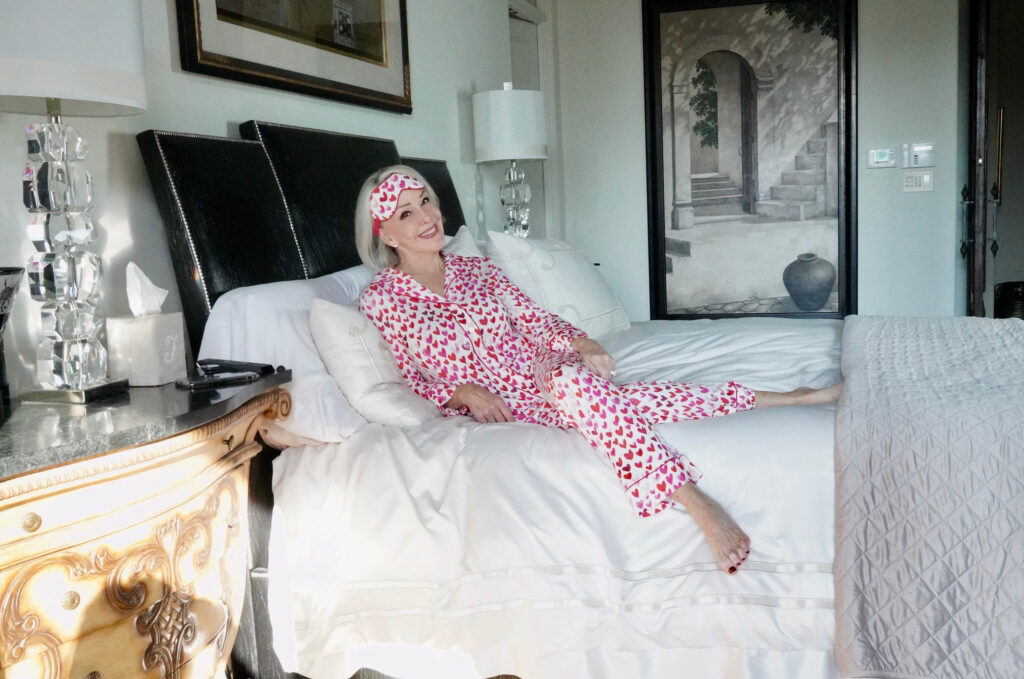 Sheree Frede of the SheShe Show lounging on her bed in heart print pajamas
