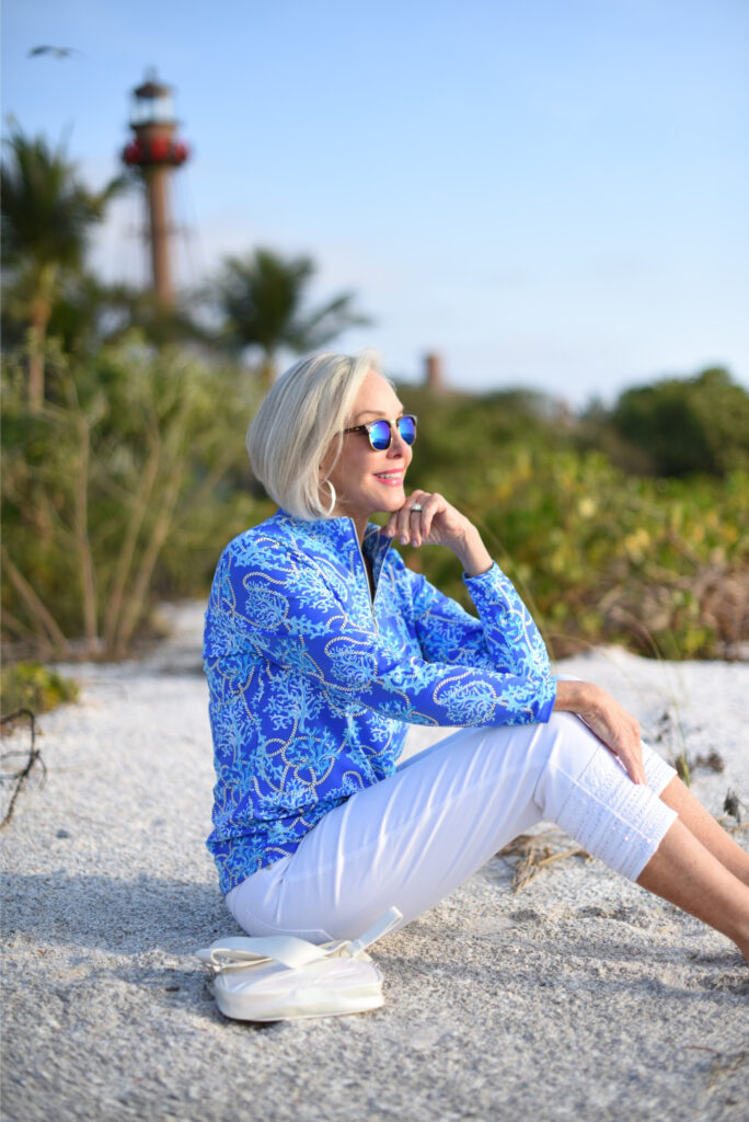 Sheree Frede of the SheSheShow white pants, long sleeve blue print zip front top, sunglasses, beach