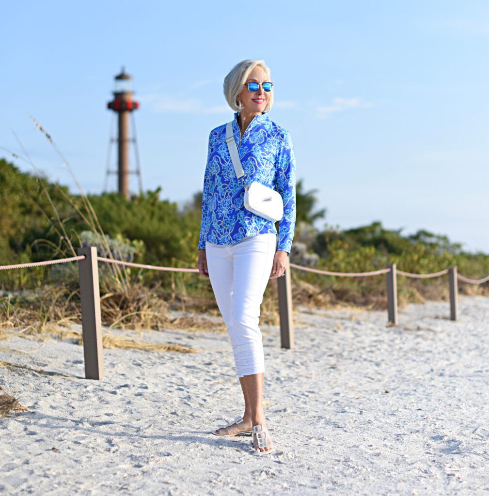 Sheree Frede of the SheSheShow white pants, long sleeve blue print zip front top, sunglasses, beach, small white bag