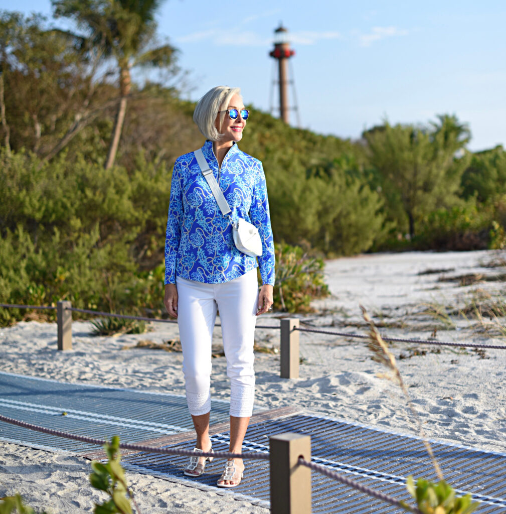 Sheree Frede of the SheSheShow white pants, long sleeve blue print zip front top, sunglasses, beach, small white bag