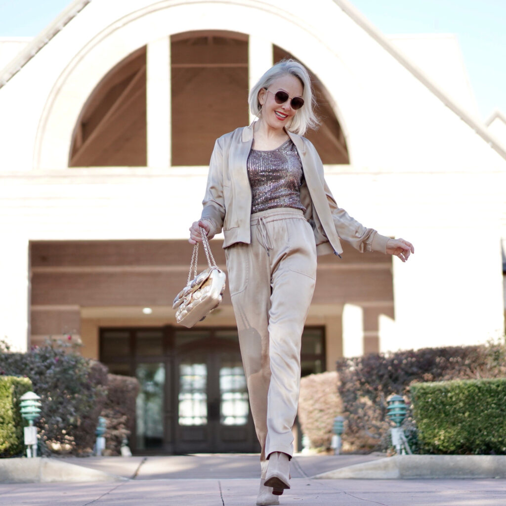 Sheree Frede of the SheShe Show wearing gold silk drawstring pants and bomber jacket with taupe suede booties