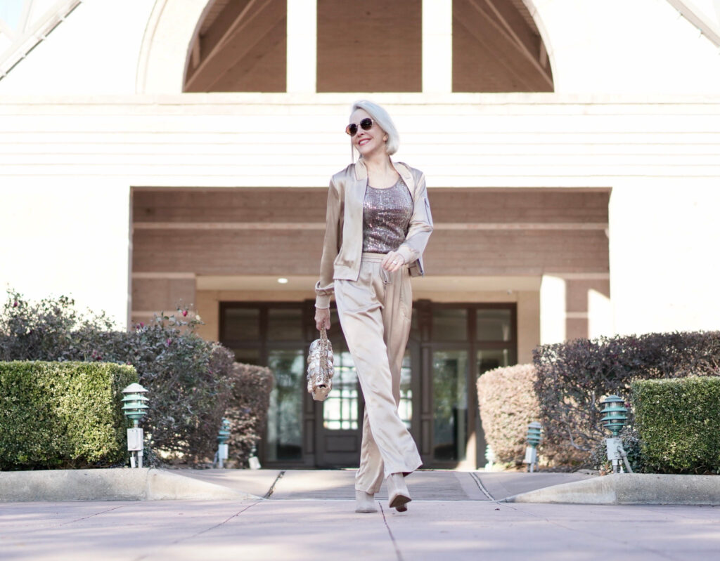 Sheree Frede of the SheShe Show wearing gold silk drawstring pants and bomber jacket with taupe suede booties