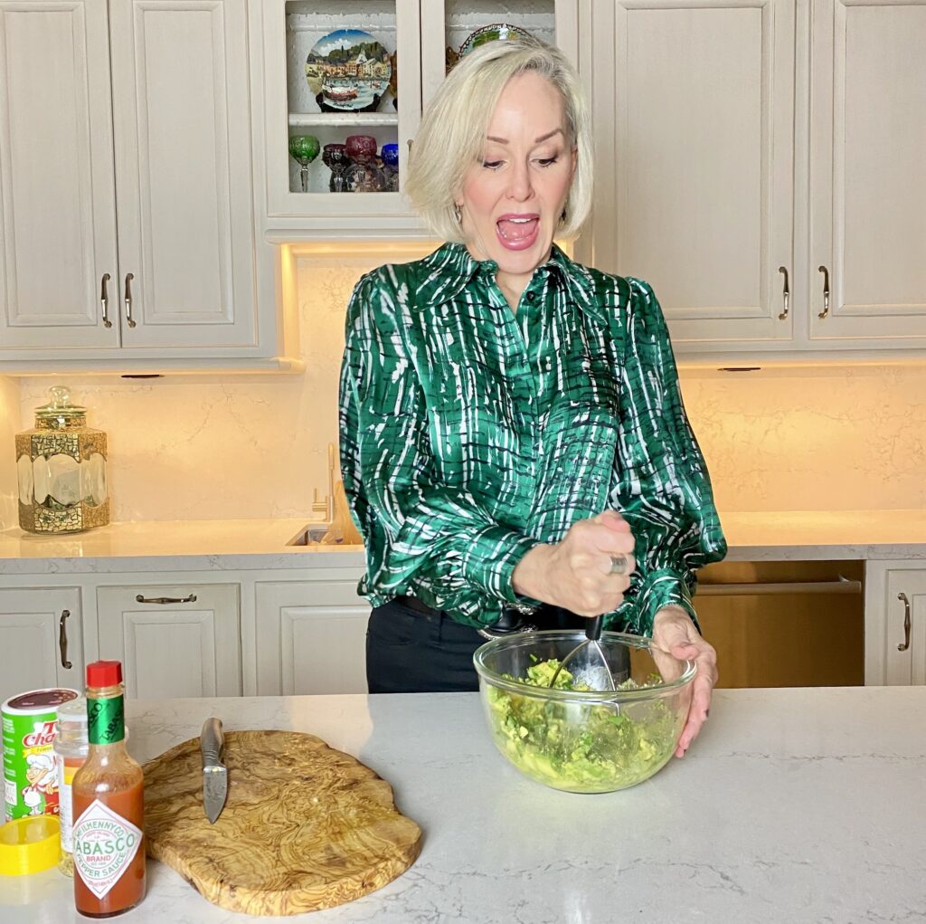 Sheree Frede of the SheShe Show in the kitchen making guacamole wearing a green print shirt