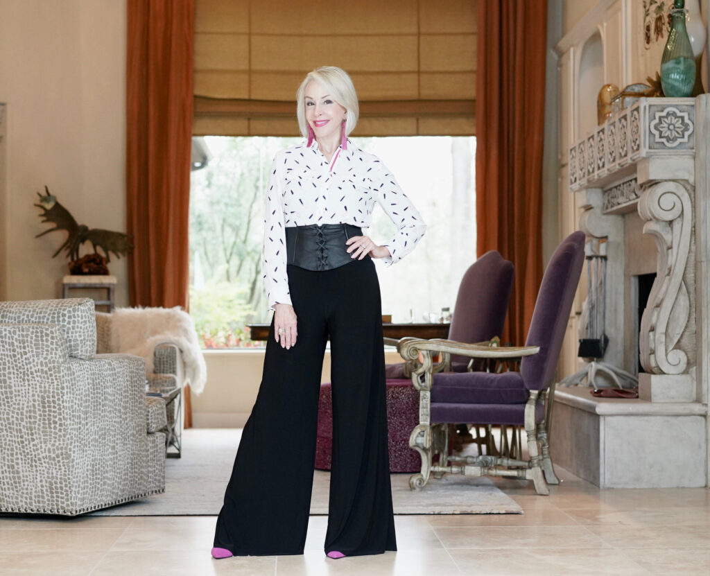 Sheree Frede of the SheShe Show standing in foyer wearing black pants and white print shirt