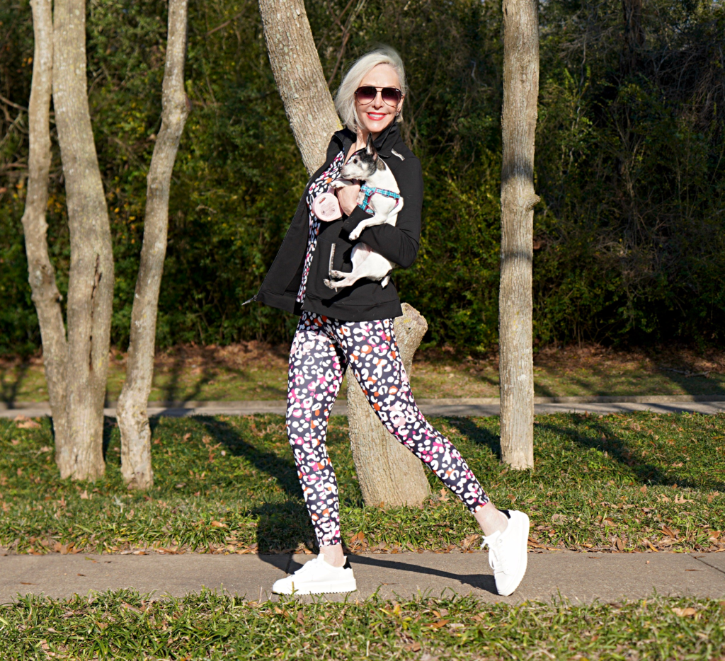 Sheree Frede of the SheShe Show walking toy fox terrrier wearing print leggings and zip knit jacket zenergy