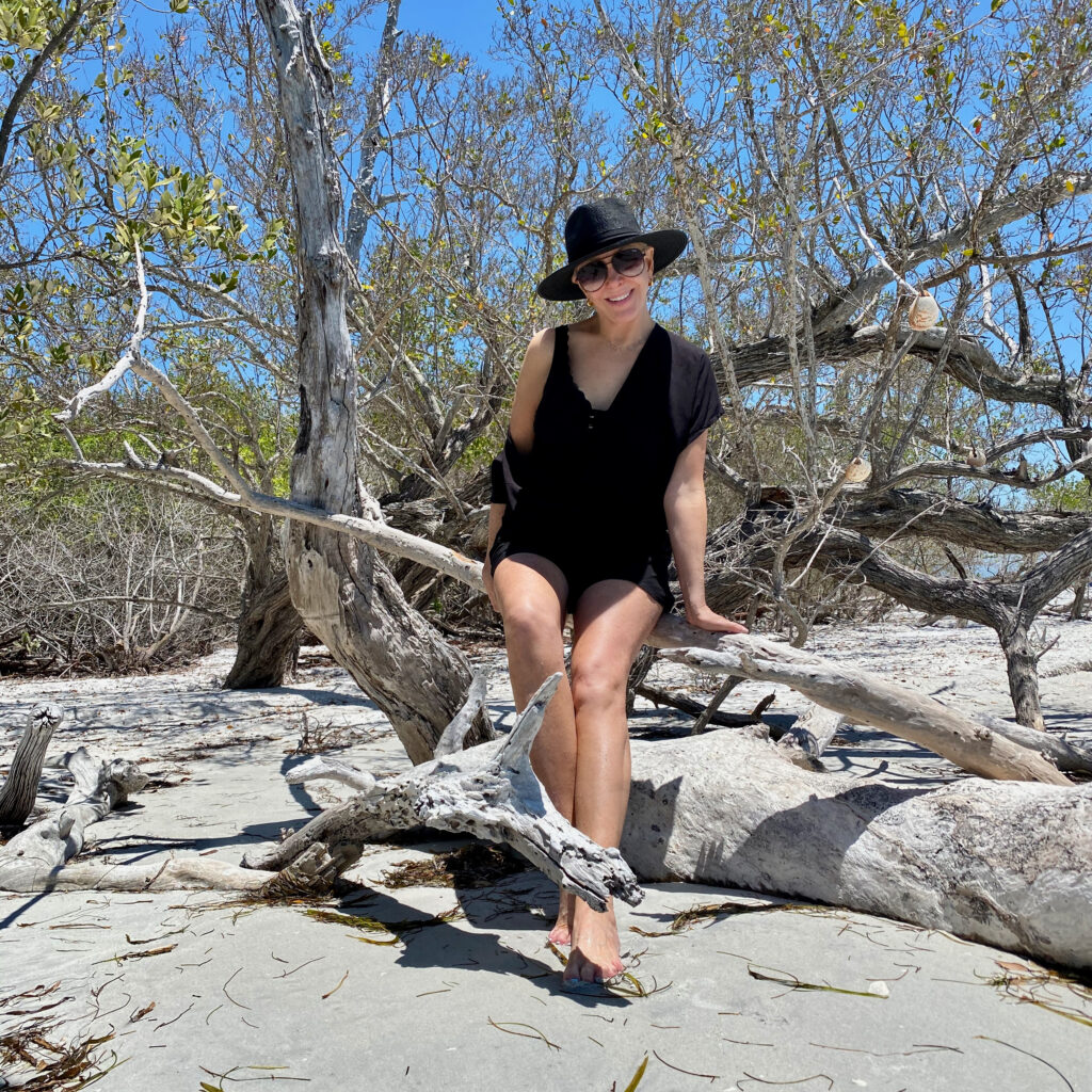 Sheree Frede of the SheShe SHow wearing a colorful swimsuit cover up and black hat