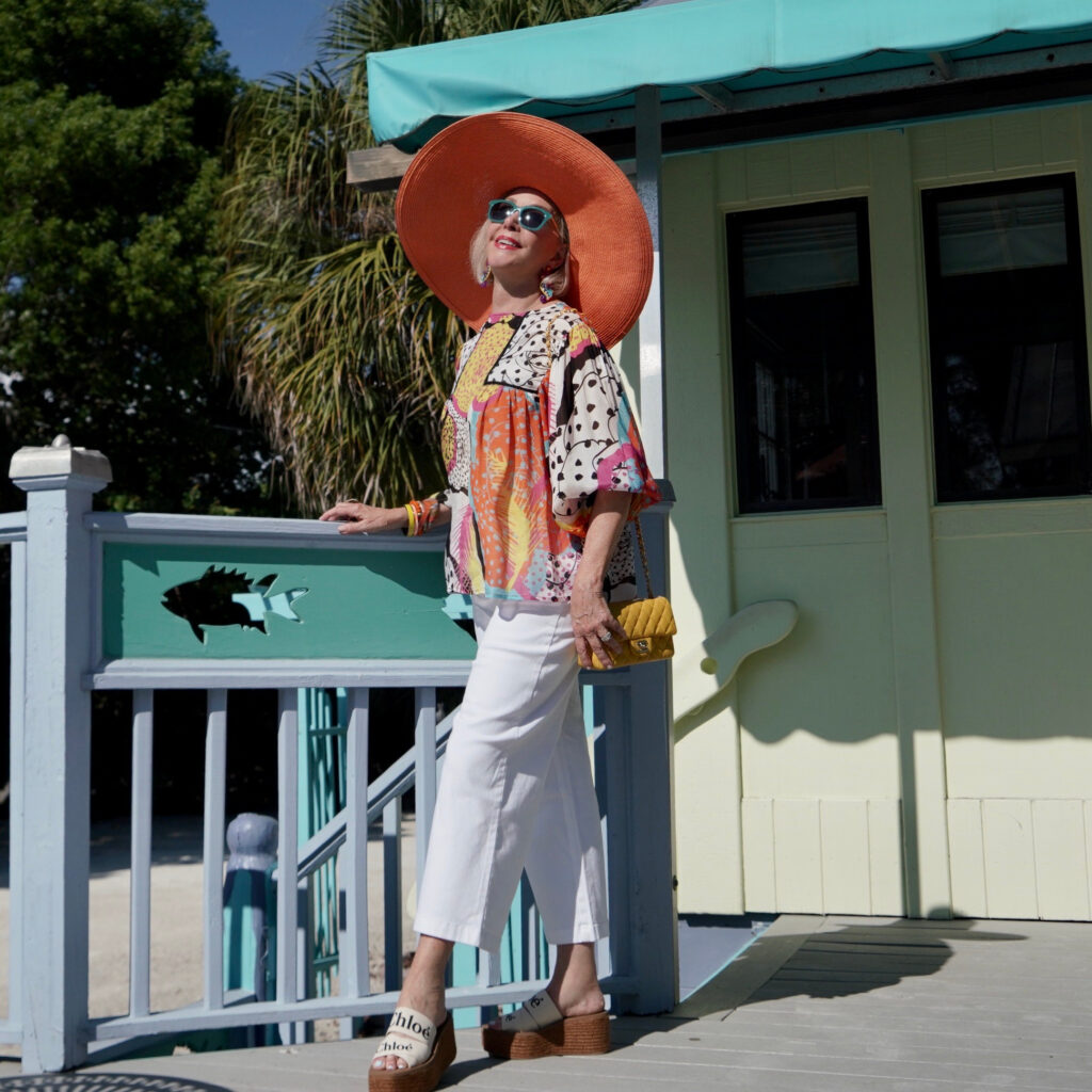 Sheree Frede of the SheShe Show wearing a multi color printed top and big orange hat