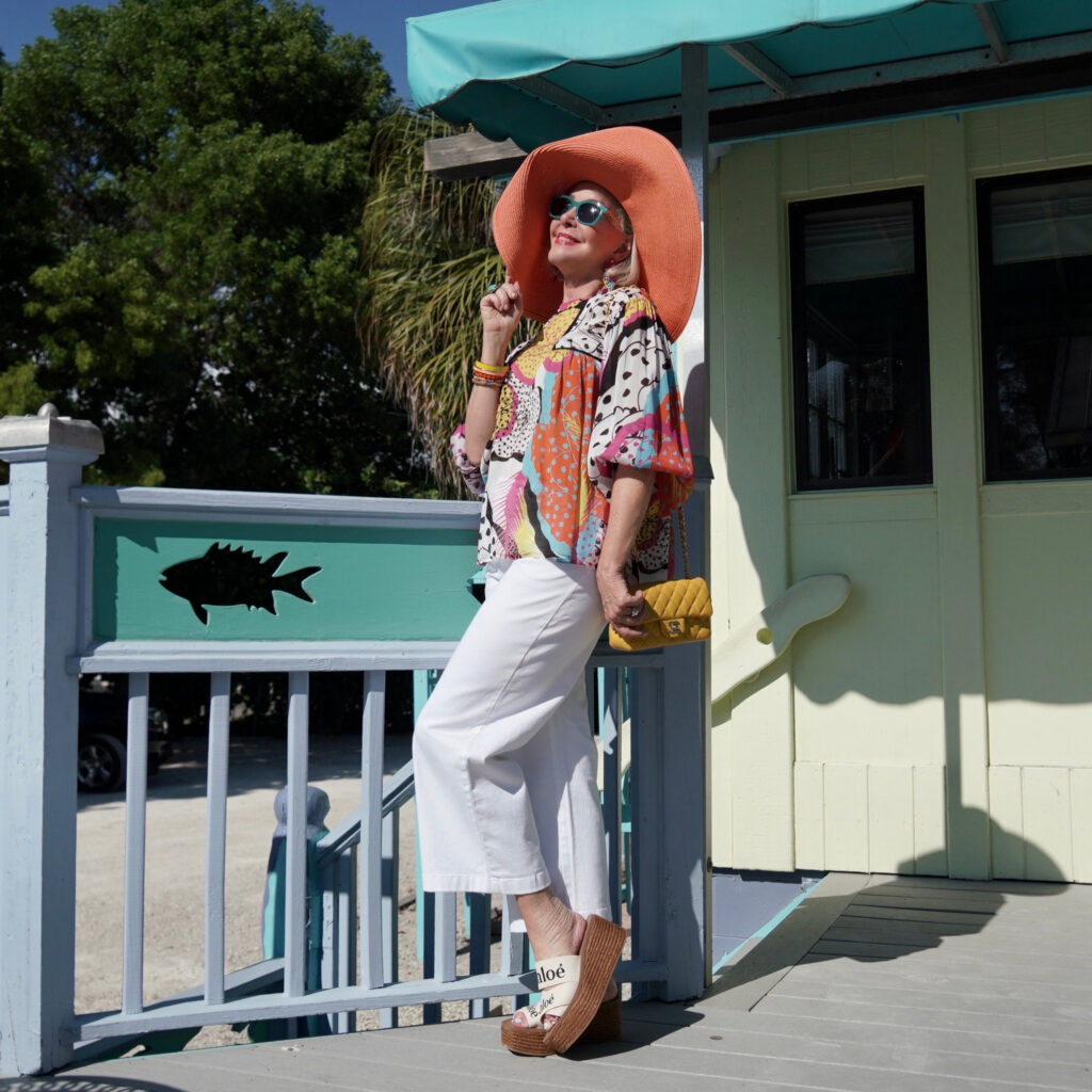 Sheree Frede of the SheShe Show wearing a multi color printed top and big orange hat