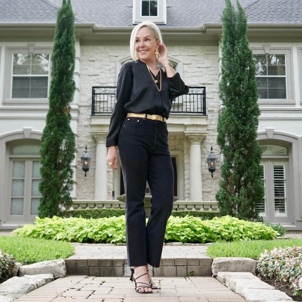 Sheree Frede of the SheShe Shoe standing n front of white house wearing all black jeans and top