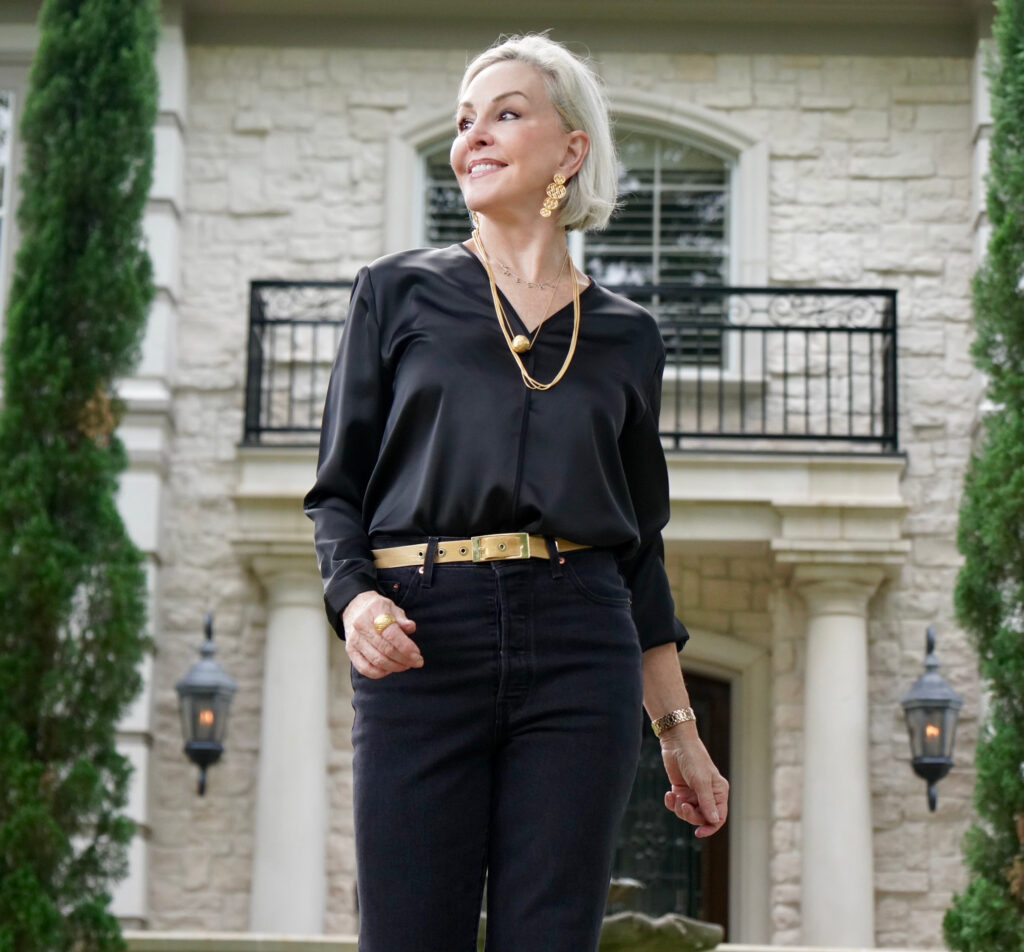 Sheree Frede of the SheShe Shoe standing n front of white house wearing all black jeans and top