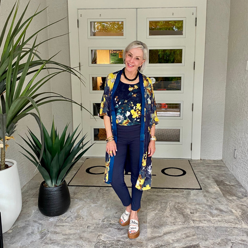 Sheree Frede of the SheShe Show standing in front of double doors wearing a navy kimono and navy pants