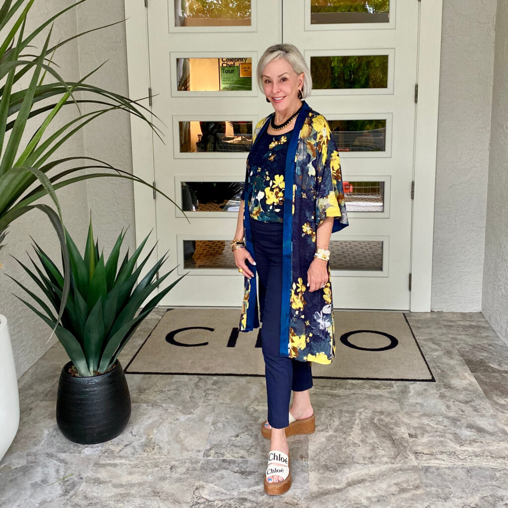 Sheree Frede of the SheShe Show standing in front of double doors wearing a navy kimono and navy pants