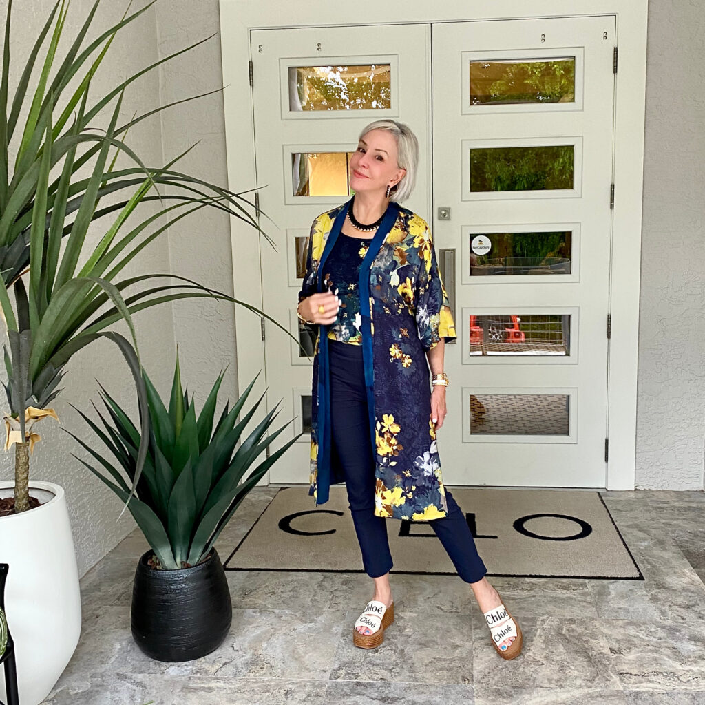 Sheree Frede of the SheShe Show standing in front of double doors wearing a navy kimono and navy pants
