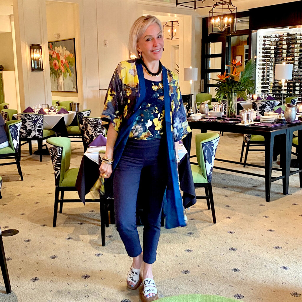 Sheree Frede of the SheShe Show standing in front of double doors wearing a navy kimono and navy pants