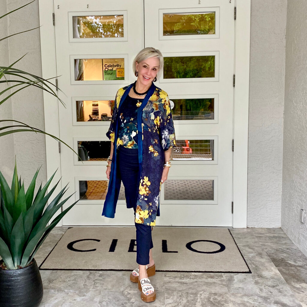 Sheree Frede of the SheShe Show standing in front of double doors wearing a navy kimono and navy pants