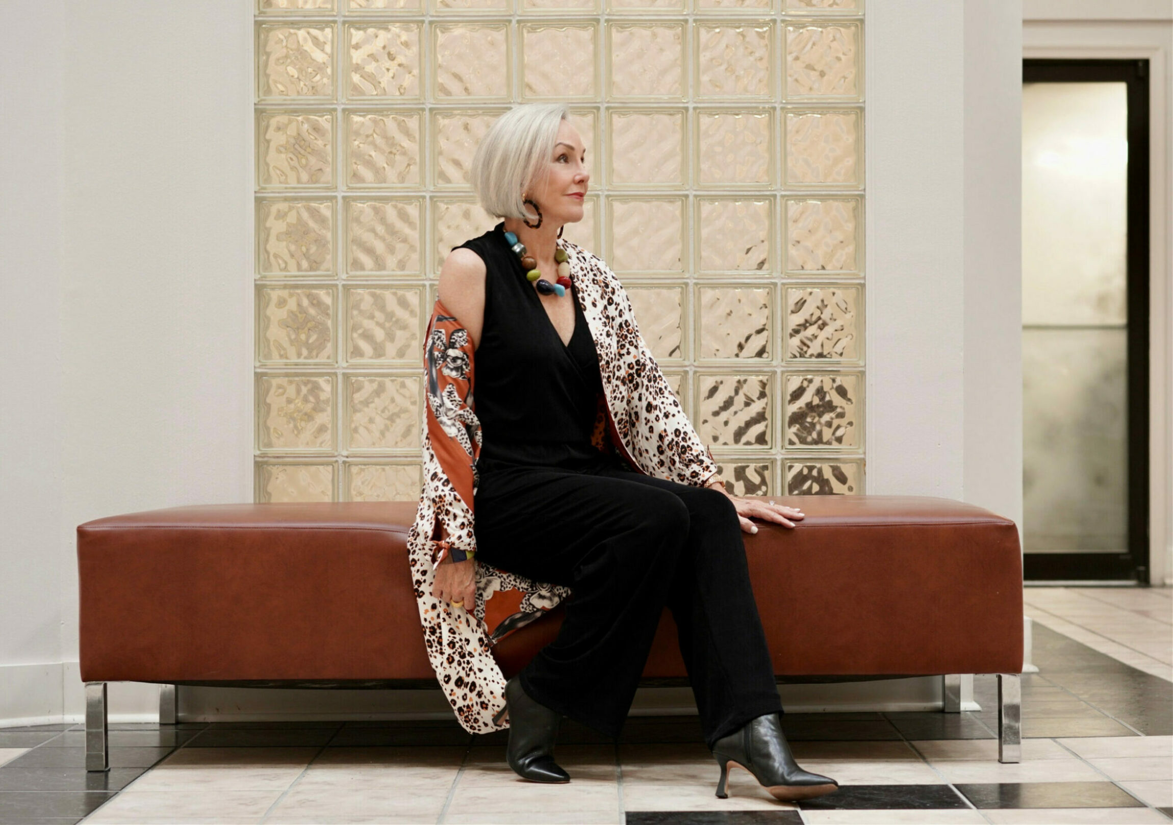 Sheree Frede of the SheShe Show wearing a black jumpsuit and burnt orange print kimono