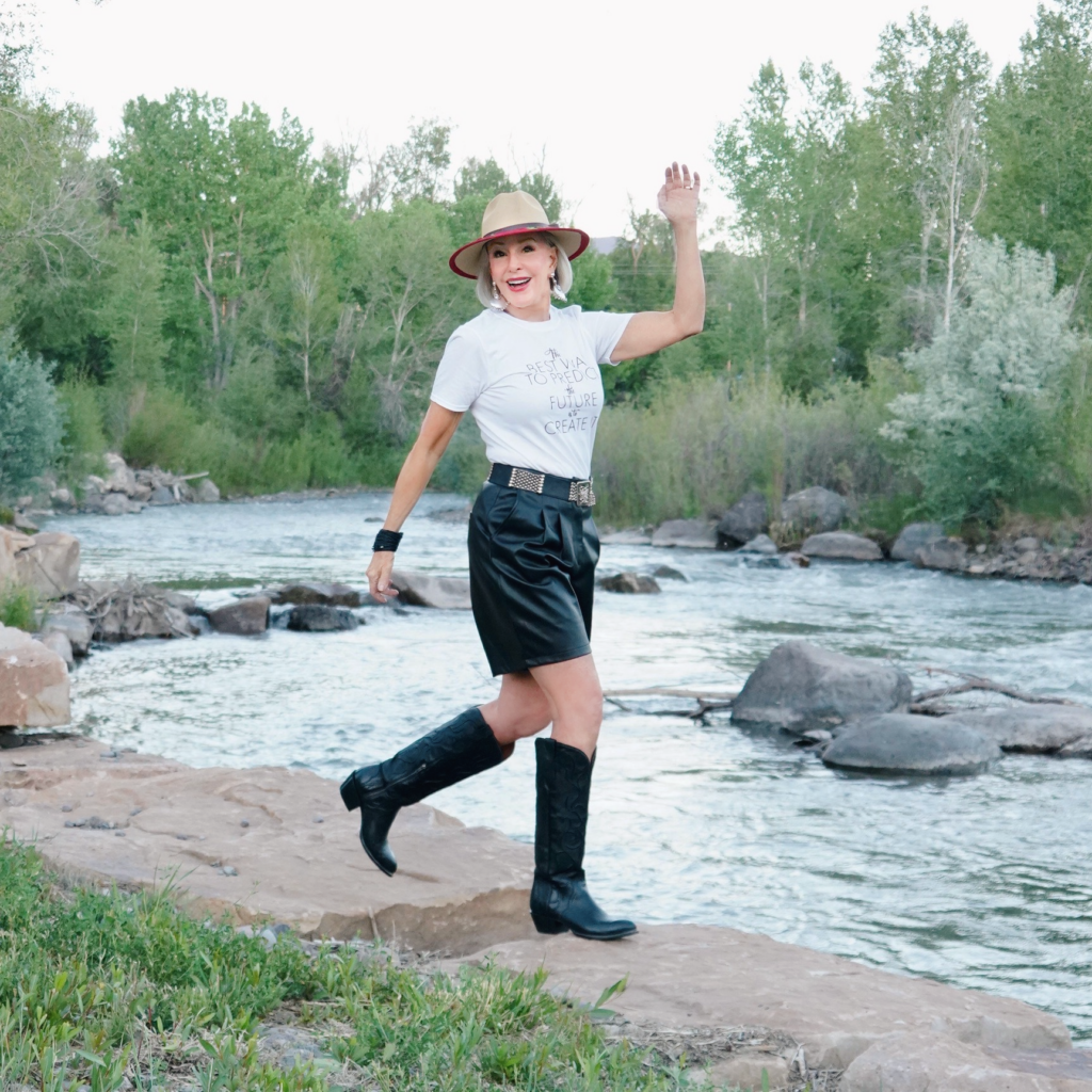 Sheree Frede of the SheShe show standing by the river wearing black leather shorts with black western boots