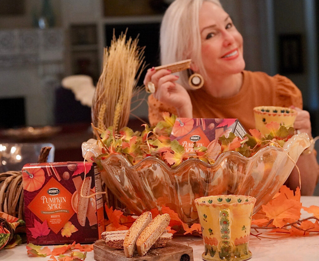 Sheree Frede of the SheShe Show sitting at kitchen island eating a Nonni's pumpkin and spice biscotti