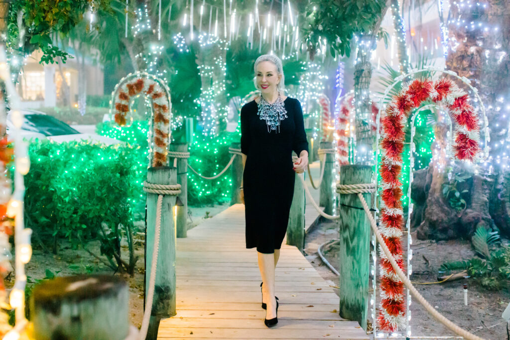 Sheree Frede of the SheSheShow walking down Candy Cane Lane on Captiva Island, Fla wearing a black dress and large crystal necklace