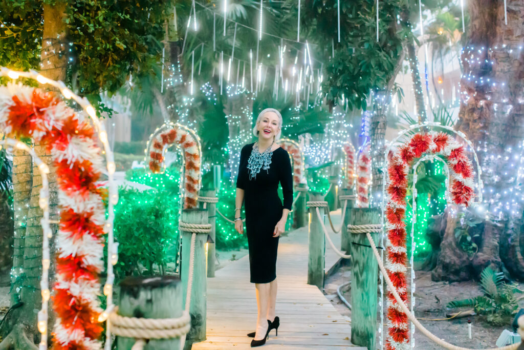 Sheree Frede of the SheSheShow walking down Candy Cane Lane on Captiva Island, Fla wearing a black dress and large crystal necklace