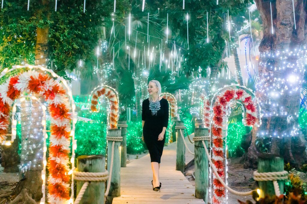 Sheree Frede of the SheSheShow walking down Candy Cane Lane on Captiva Island, Fla wearing a black dress and large crystal necklace