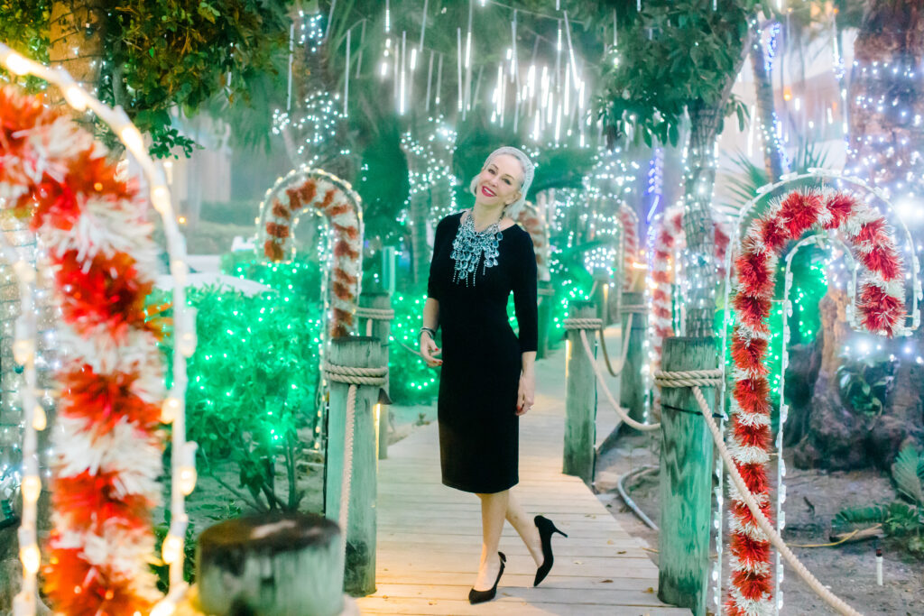 Sheree Frede of the SheSheShow walking down Candy Cane Lane on Captiva Island, Fla wearing a black dress and large crystal necklace fior her New Years Look