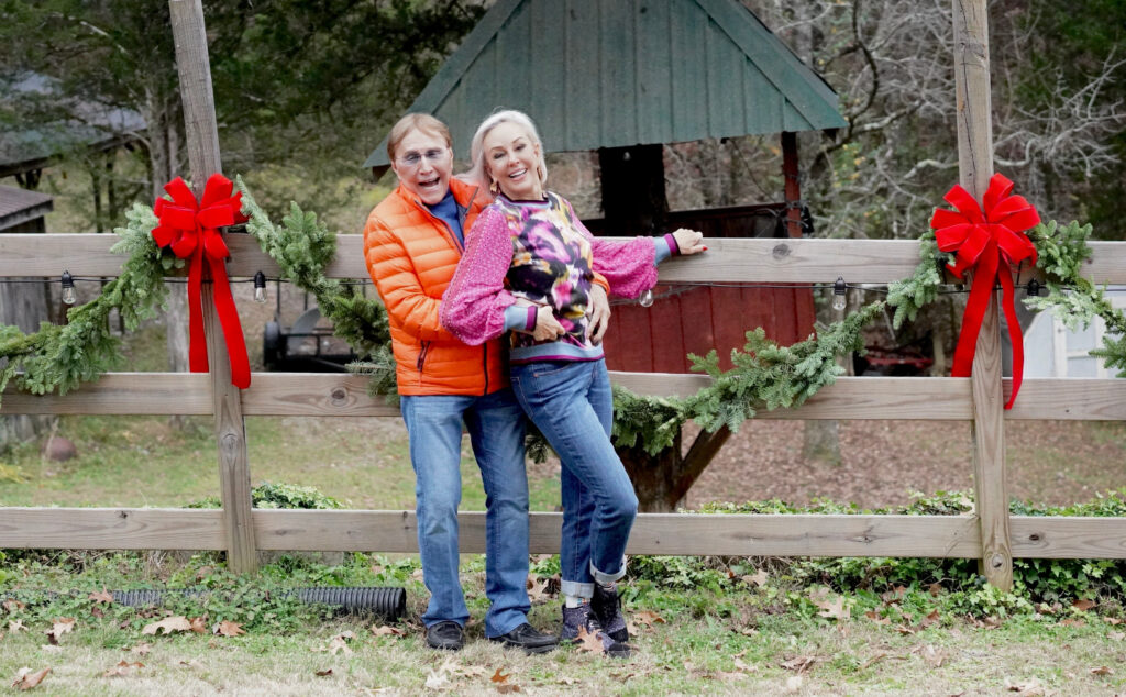 Sheree and Norman Frede posing by old fence wearing outer wear