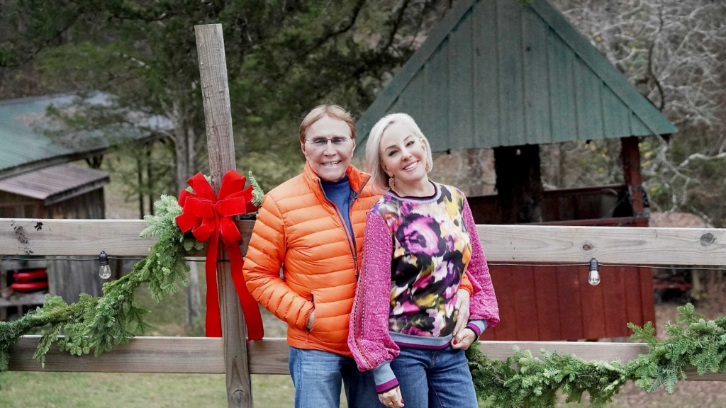 Sheree and Norman Frede posing by old fence wearing outer wear