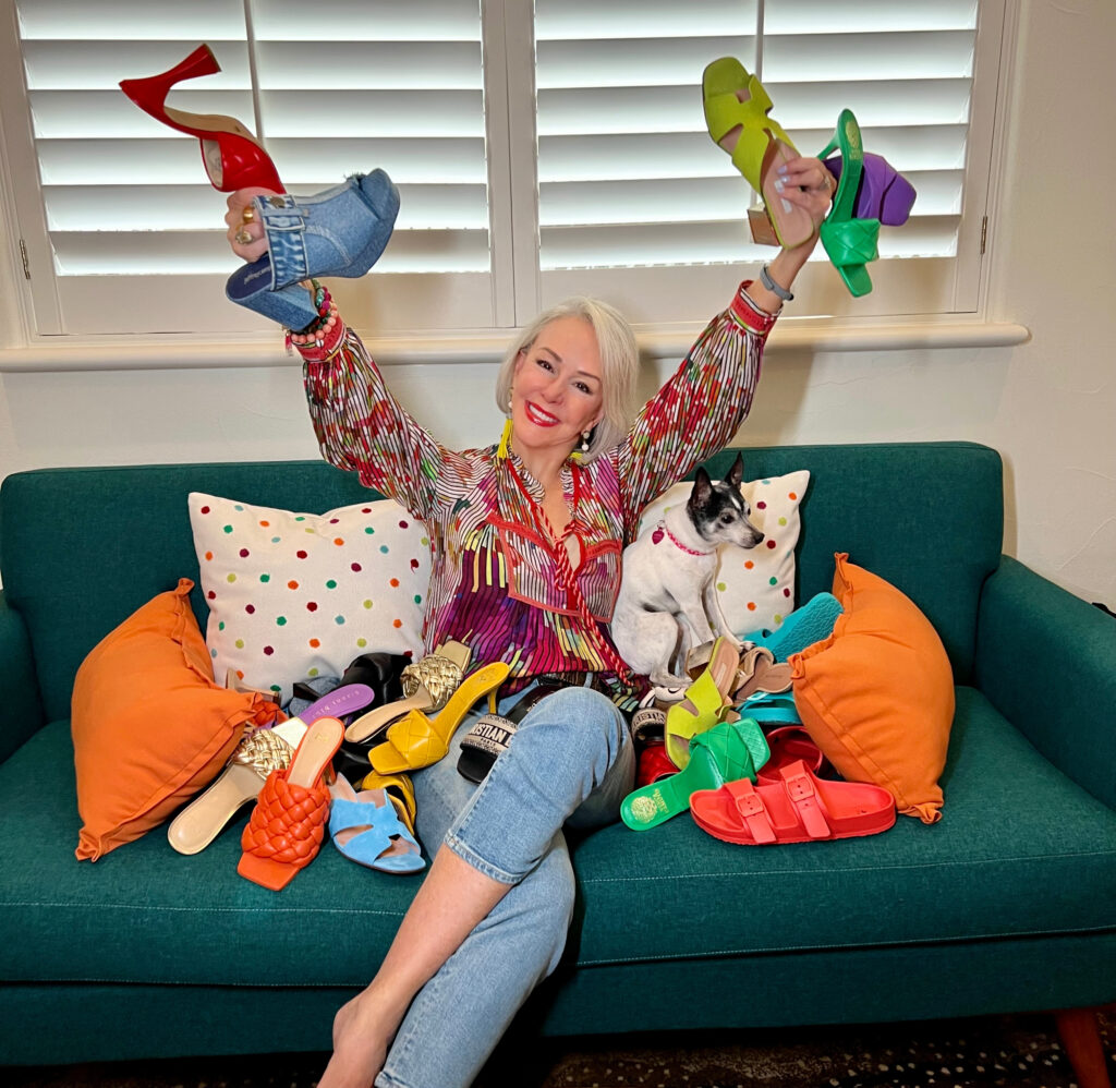 Sheree Frede with her dog on sofa with 12 pairs of colorful sandals