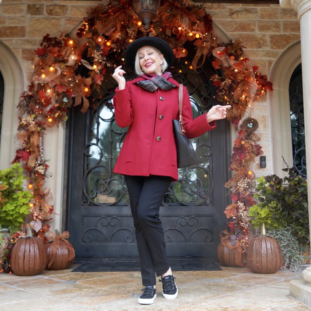 SheShe infront of welcoming front door for fall decor in Red wool pea coat and scarf