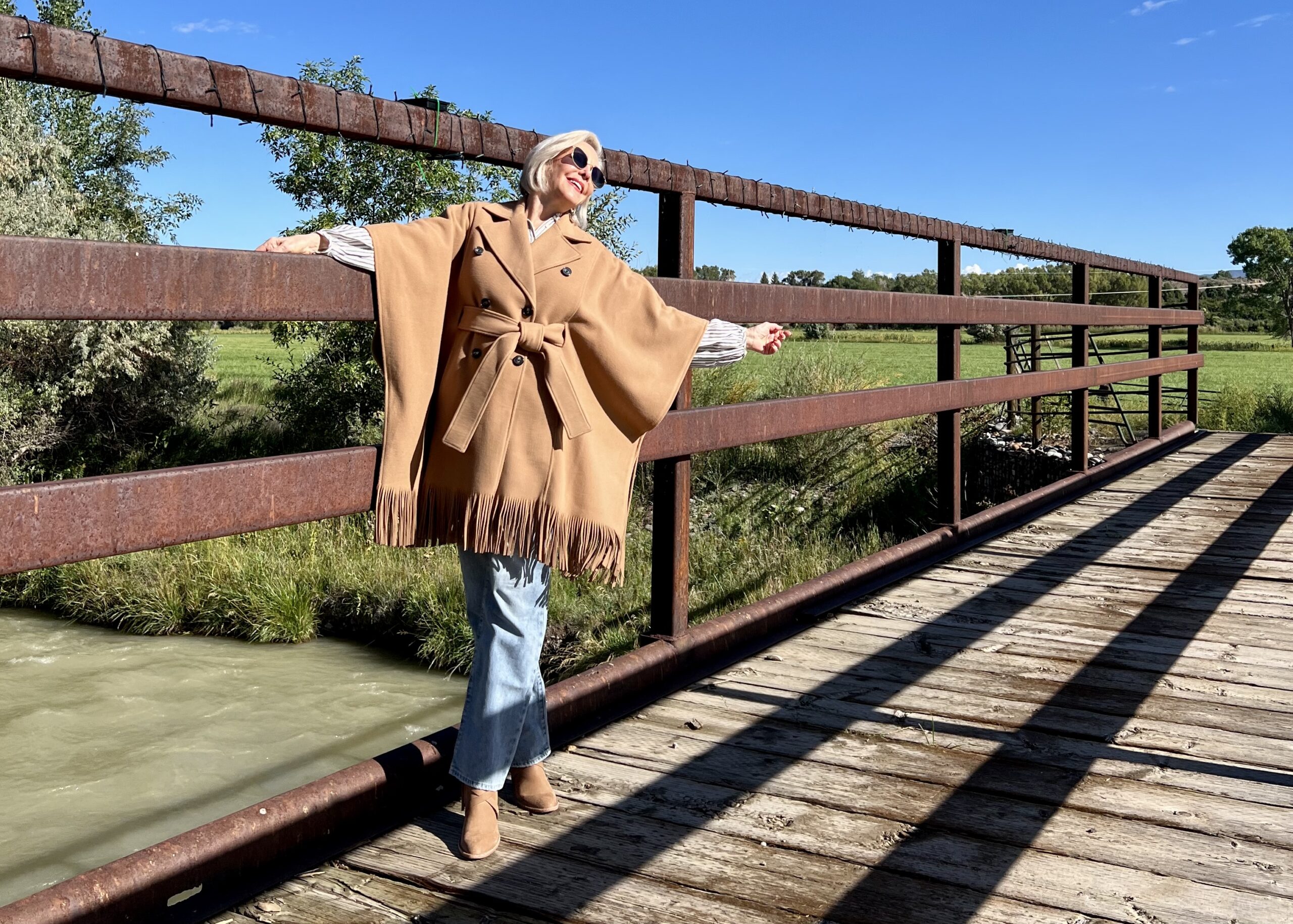 Sheree wearing a camel colored wool fringe poncho coat