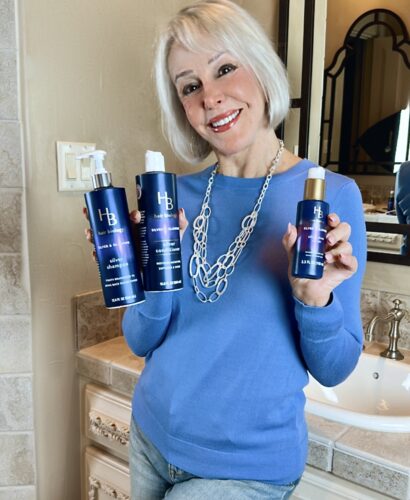 Sheree Frede of the SheSheShow holding 3 products from Hair Biology