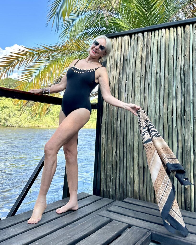 Sheree Frede wearing a black swimsuit by the river from Chico's