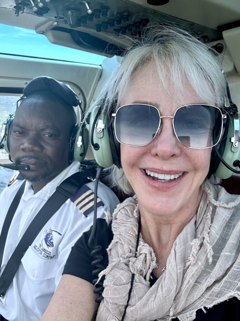 Sheree Frede sitting in front seat of helicopter with pilot