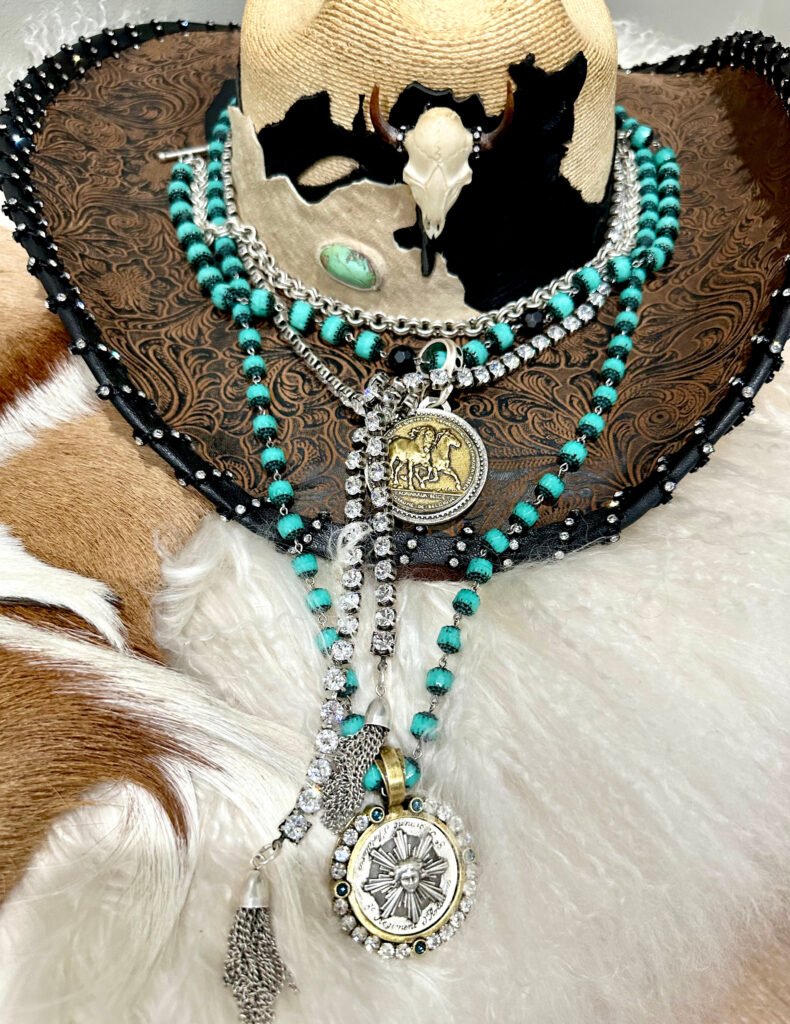 Turquoise and medallion French Kande jewelry displayed on a western hat