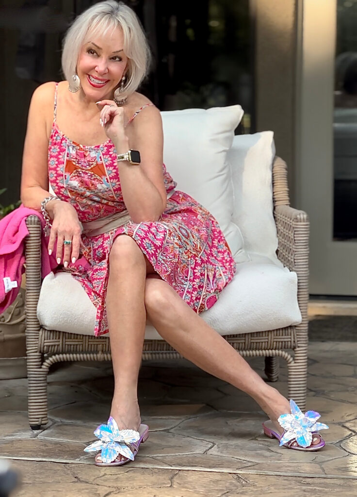 Sheree Frede sitting in a chair wearing metallic flower slide sandals