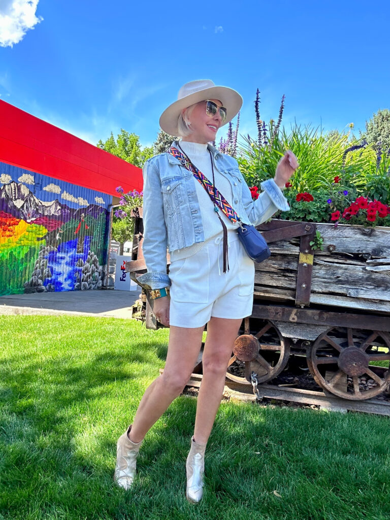 Sheree wearing an off white 2 pc knit shorts set with crop denim jacket, booties ane hat