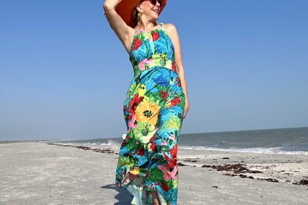 Sheree Frede of SheSheShow on beach in floral dress for resort wear